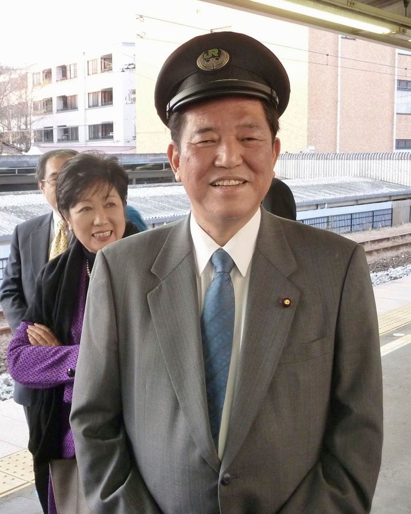 Minister in charge of regional issues Shigeru Ishiba, wearing a JR railway company's cap, smiles at an event by ruling LDP members at Kamakura station in Kamakura, south of Tokyo, December, 2014. (Kyodo News via AP)