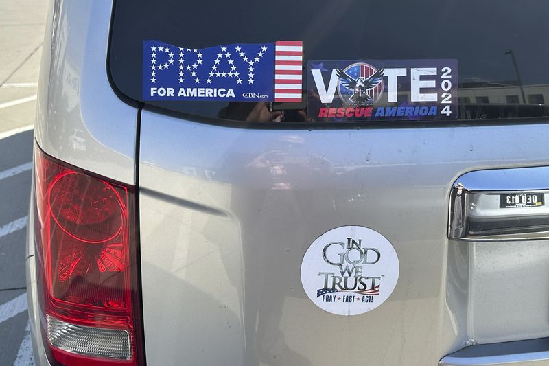 A vehicle outside the Mid-America Center in Council Bluffs, Iowa, displays sentiments similar to those voiced at the Opening the Heavens conference held there on Friday, Sept. 13, 2024. (AP Photo/Peter Smith)