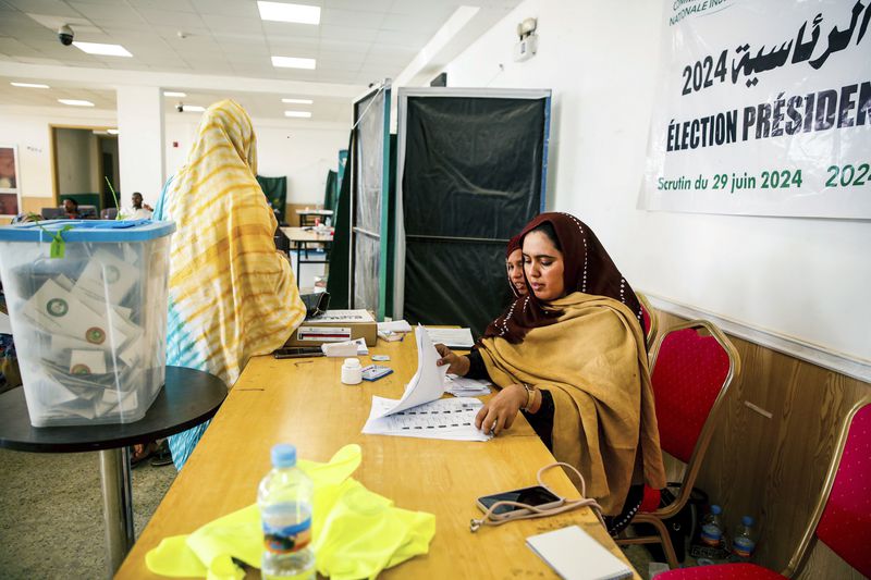 A woman sorts out ballot papers, during the presidential election, in Nouakchott, Mauritania, Saturday, June 29, 2024. Mauritanians are voting for their next president, with the incumbent Mohamed Ould Ghazouani widely expected to win the vote after positioning Mauritania as a strategic ally of the West in a region swept by coups and violence. (AP Photo/Mamsy Elkeihel)