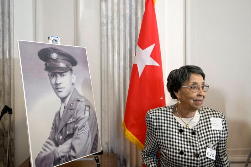 Joann Woodson stands near a portrait of her husband U.S. Army Staff Sgt. Waverly Woodson Jr., prior to a ceremony to posthumously award the Distinguished Service Cross to him, a medic who was part of the only Black combat unit to take part in the D-Day invasion of France during World War II, on Capitol Hill, in Washington, Tuesday, Sept. 24, 2024. (AP Photo/Rod Lamkey, Jr.)