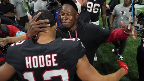 Atlanta Falcons head coach Raheem Morris celebrates with wide receiver KhaDarel Hodge (12) after scoring against the Tampa Bay Buccaneers during overtime in an NFL football game Thursday, Oct. 3, 2024, in Atlanta. (AP Photo/John Bazemore)