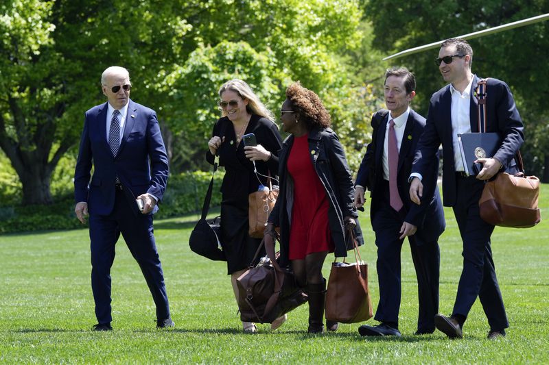 FILE - President Joe Biden, from left, walks with White House deputy chief of staff Annie Tomasini, White House press secretary Karine Jean-Pierre, White House deputy chief of staff Bruce Reed and White House communications director Ben LaBolt, as they cross the South Lawn of the White House in Washington, April 26, 2024, after returning from a trip to New York. (AP Photo/Susan Walsh, File)