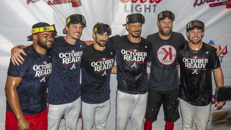 Atlanta Braves players celebrate in the locker room after clinching a wild-card playoff berth after the second baseball game of a doubleheader against the New York Mets, Monday, Sept. 30, 2024, in Atlanta. (AP Photo/Jason Allen)