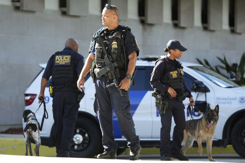 Department of Homeland Security officers patrol outside the Paul G. Rogers Federal Building and U.S. Courthouse, where Ryan Wesley Routh, 58, suspected in an apparent assassination attempt targeting former President Donald Trump, will be attending a hearing, Monday, Sept. 23, 2024, in West Palm Beach, Fla. (AP Photo/Wilfredo Lee)