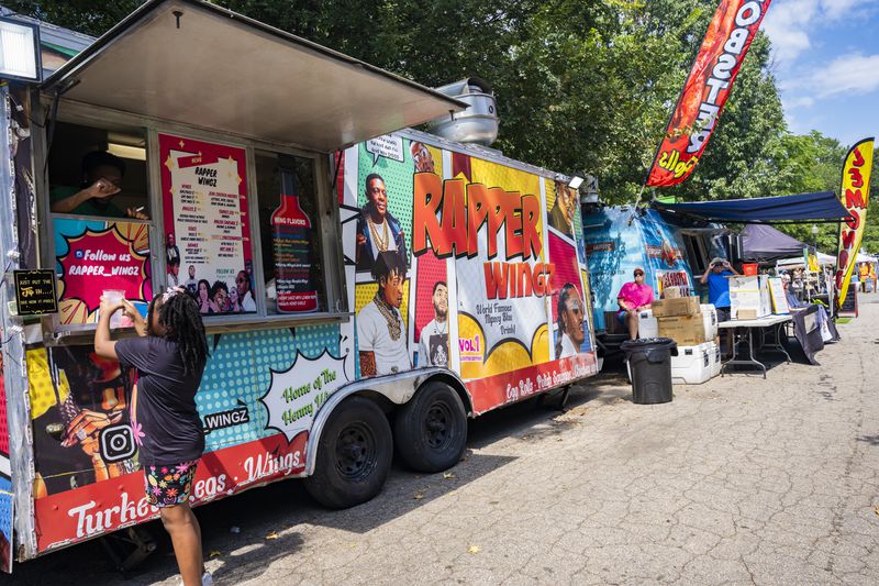 Rapper Wingz sells food at the Pure Heat Community Festival in Piedmont Park on Sunday, Sept. 1, 2024.  (Olivia Bowdoin for the AJC). 