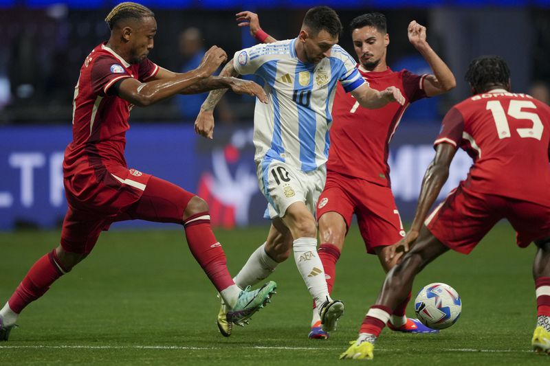 Argentina's Lionel Messi, center, and Canada's Stephen Eustaquio battle for the ball during a Copa America Group A soccer match in Atlanta, Thursday, June 20, 2024. (AP Photo/Jason Allen)