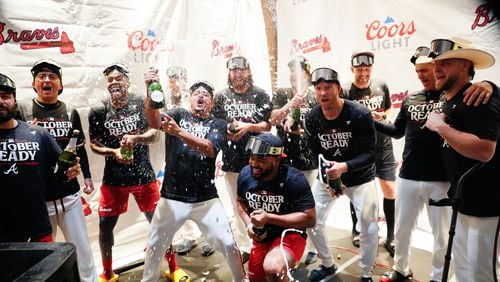 Braves players celebrate with champagne after their 3-0 win over the Mets in the second game of Monday’s doubleheader at Truist Park. 
(Miguel Martinez/ AJC)