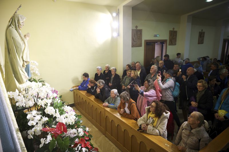 Pilgrims say their prayers next to the statue of the Virgin Mary inside the St. James Church in Medjugorje, Bosnia, Thursday, Sept. 19, 2024. (AP Photo/Armin Durgut)