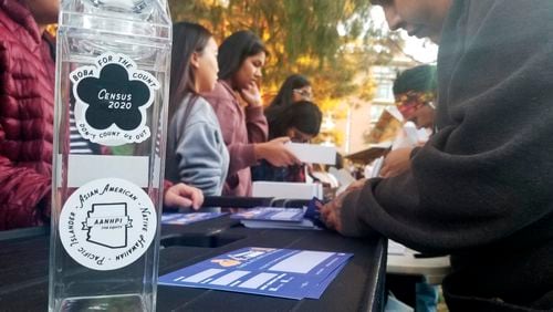 FILE - A woman fills out a pledge card for the U.S. Census in exchange for a reusable boba tea carton at a boba drink competition in Phoenix on Jan. 3, 2020. According to a new study released in June 2024, adding a citizenship question to the census reduces the participation of people who aren’t U.S. citizens. (AP Photo/Terry Tang, File)