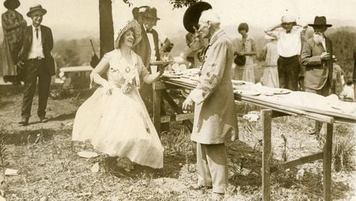 From the original caption, published in 1926: "Major J.L. McCollum, veteran of the Civil War, doffs his hat to Mrs. Warren Vinson, dressed as a girl of the old south, at exercises held by veterans of the Blue and the Gray at Marietta, Ga., June 26, in commemoration of the 62nd anniversary of the Battle of Kennesaw Mountain."