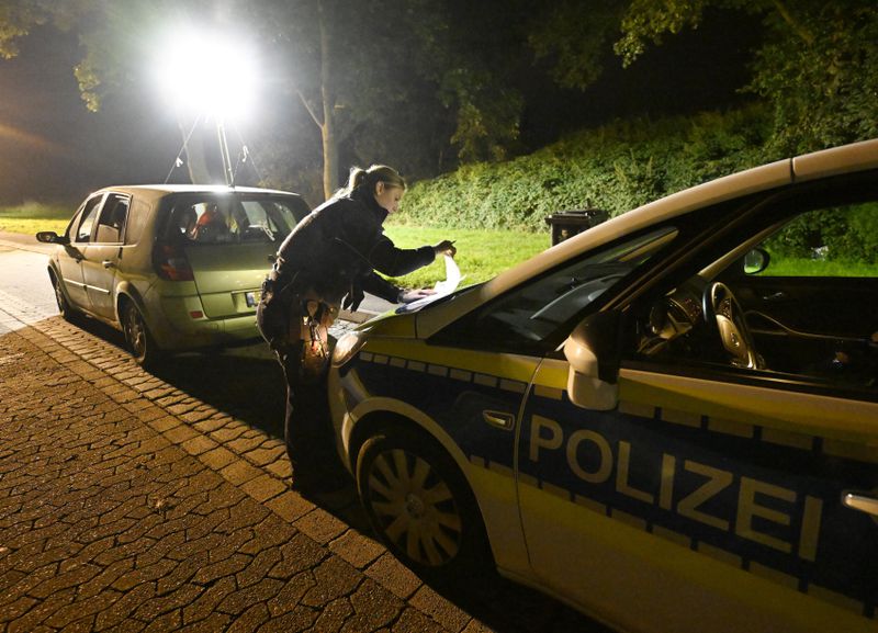 A police officer checks vehicles near the border with Belgium in Aachen, Germany, Monday, Sept. 16, 2024 Roberto Pfeil/dpa via AP)