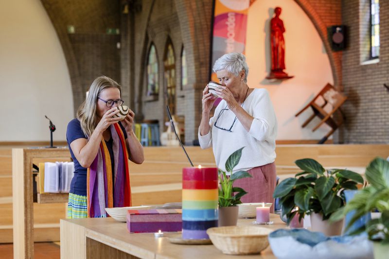 Laywomen Nancy Speeckaert, left, and Marijke Devaddere drink wine after the Eucharistic Prayer during a service they led at the Don Bosco church in Buizingen, Belgium, Sunday, Sept. 8, 2024. (AP Photo/Geert Vanden Wijngaert)