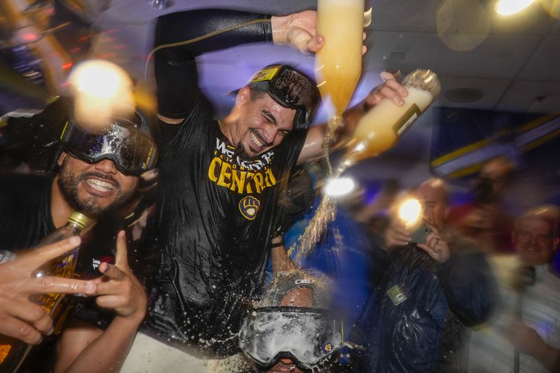 Milwaukee Brewers' Willy Adames douces Enoli Paredes after a baseball game against the Philadelphia Phillies Wednesday, Sept. 18, 2024, in Milwaukee. The Brewers won 2-1 and clinched the National League Central division. (AP Photo/Morry Gash)