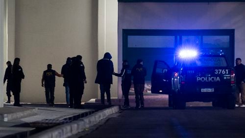 Police escort French rugby players Oscar Jegou, fourth right, and Hugo Auradou, center, to the police station as they arrive in Mendoza, Argentina, Thursday, July 11, 2024. The players were arrested following a complaint for sexual assault filed against them after France played Argentina in a test rugby match in Mendoza on July 6. (AP Photo/Ignacio Blanco)