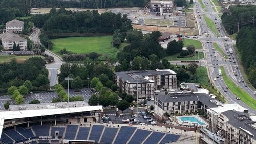 Aerial photo shows the17.5-acre site (middle), where a mixed-use development has been approved with more than 300 apartments, Wednesday, August 30, 2023, in Buford. The site's proximity to the Northside medical building being constructed (background) across the street, plus Coolray Field and the Exchange shopping center (foreground). (Hyosub Shin / Hyosub.Shin@ajc.com)