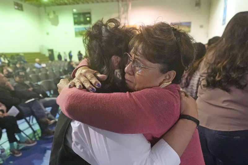 School teacher Sherry Crutcher, right, hugs Terri Ann Cota at a memorial service for Cota's father, Marvin, on March 14, 2024, in Owyhee, Nev., on the Duck Valley Indian Reservation that straddles the Nevada-Idaho border. (AP Photo/Rick Bowmer)