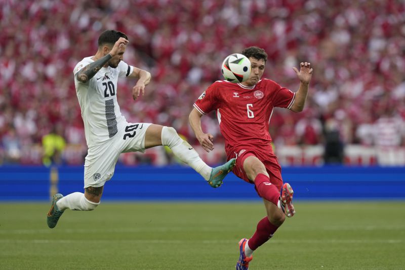 Slovenia's Petar Stojanovic, left, and Denmark's Andreas Christensen fight for the ball during a Group C match between Slovenia and Denmark at the Euro 2024 soccer tournament in Stuttgart, Germany, Sunday, June 16, 2024. (AP Photo/Antonio Calanni)