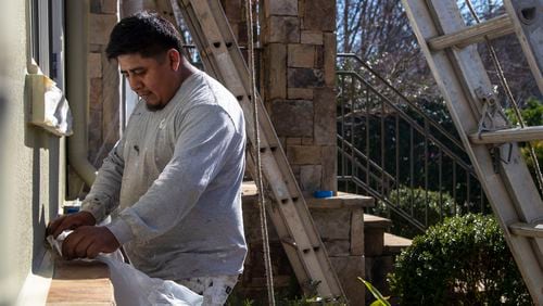 Georgia's economy continues to slog slowly back. Among the jobs  with the strongest growth are those that provide home services. Here, 360 Painting of North Georgia painter Anibal Bail uses tape and painter’s plastic to prepare a house for painting at a residence in Atlanta’s Virginia Highlands community. (Alyssa Pointer / Alyssa.Pointer@ajc.com)