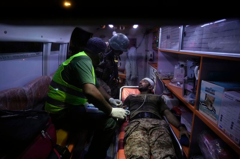 A Pakistani security official, who was injured in explosion receives treatment inside an ambulance outside the Karachi airport, Pakistan, early Monday, Oct. 7, 2024. (AP Photo/Fareed Khan)