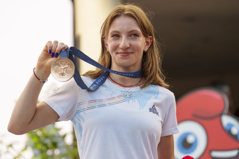 Romanian gymnast Ana Barbosu poses with the bronze medal for her women's artistic gymnastics individual floor performance at the Paris 2024 Olympics, after receiving it during a ceremony at the Romanian Olympic and Sports Committee, in Bucharest, Romania, Friday, Aug. 16, 2024. American gymnast Jordan Chiles called an arbitration panel's decision that dropped her out of the bronze medal position in the floor exercise at the Paris Olympics "unjust" and a "significant blow" in a message posted on social media Thursday. (AP Photo/Vadim Ghirda)