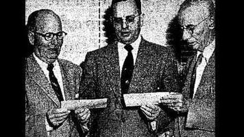 Atlanta and Fulton County officials receive large tax payment checks from a Southern Bell Telephone and Telegraph Co. district manager (center), as seen in an Atlanta Constitution article from Nov. 26, 1953.