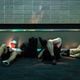 Brian Hauk of Detroit (left) looks at his phone while other stranded travelers sleep at the Hartsfield-Jackson airport domestic terminal late in the evening in Atlanta on Saturday, July 20, following a global technology outage that has hampered airlines and other industries. (Arvin Temkar / AJC)