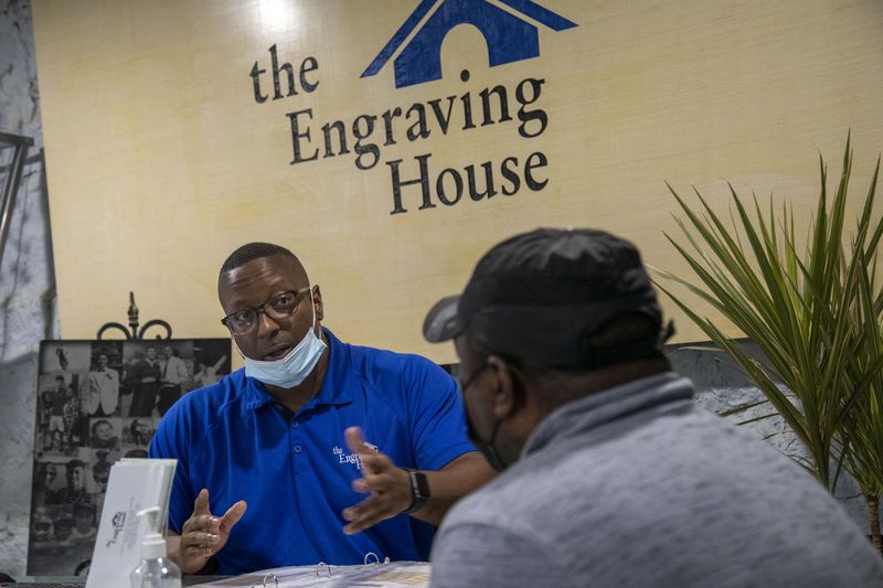 Troy Vincent, founder of The Engraving House, speaks with a client during a consultation in Lithonia, Thursday, October 7, 2021. (Alyssa Pointer/ Alyssa.Pointer@ajc.com)