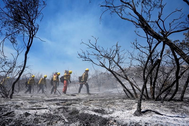 Members of Riverside County Cal Fire monitor for hot spots while battling the Airport Fire Wednesday, Sept. 11, 2024, in El Cariso Village, in unincorporated Riverside, County, Calif. (AP Photo/Gregory Bull)