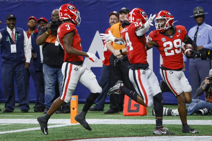 Georgia Bulldogs defensive back Christopher Smith (29) celebrates with Malaki Starks (24) and Kamari Lassiter (3) after running back a blocked LSU Tigers field goal attempt for 95 yards and a touchdown during the first half of the SEC Championship Game at Mercedes-Benz Stadium in Atlanta on Saturday, Dec. 3, 2022. (Bob Andres / Bob Andres for the Atlanta Constitution)