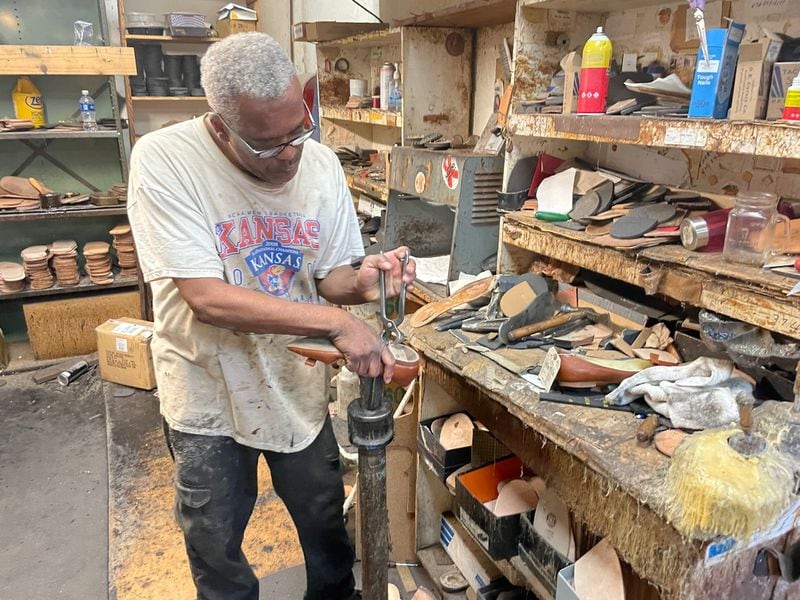 Veteran shoe cobbler Terry Cousin takes the sole off a pair of shoes. Mark Shemaria, president of Bennie's Shoes, said repairs have helped keep the business afloat.