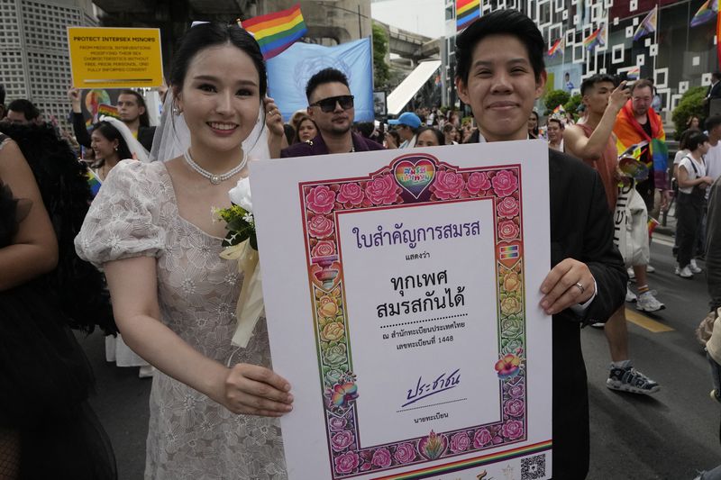 FILE - Participants hold posters celebrating equality in marriage during the Pride Parade in Bangkok, Thailand, on June 1, 2024. Thailand’s Senate voted overwhelmingly on Tuesday, June 18, 2024 to approve a marriage equality bill, clearing the last legislative hurdle for the country to become the first in Southeast Asia to enact such a law. (AP Photo/Sakchai Lalit, File)