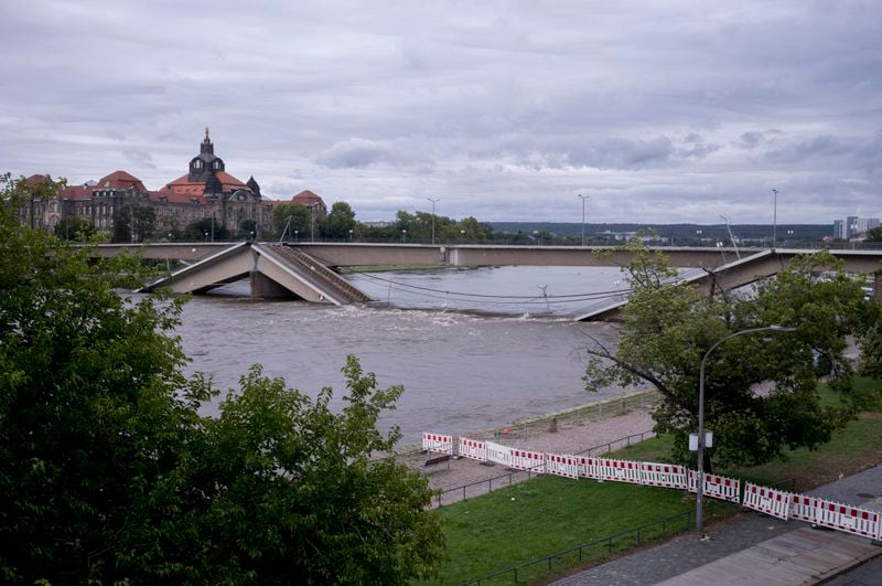 A view of the partially collapsed Carolabrücke bridge over the Elbe, which is rising rapidly due to upcoming flood waters, in front of the state chancellery in Dresden, Germany, Sunday, September 15, 2024. (AP Photo/Markus Schreiber)