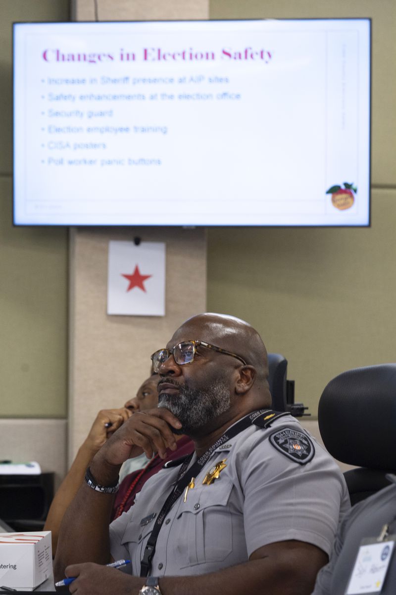 Maj. Larry White of the Cobb County Sherriff's Department, listens to a speaker during an election security training session at Cobb County Emergency Management headquarters, Aug. 23, 2024, in Marietta. (AP Photo/John Bazemore)