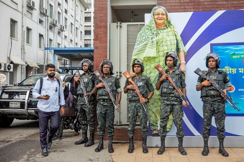 FILE - Military personnel stand in front of a portrait of Prime Minister Sheikh Hasina in Dhaka, Bangladesh, on July 30, 2024, during a national day of mourning to remember the victims of recent deadly clashes. (AP Photo/Rajib Dhar, File)