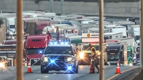 Traffic was shut down for hours on I-75 South in Cobb County after a tractor-trailer carrying barrels of brake fluid crashed and caught on fire.