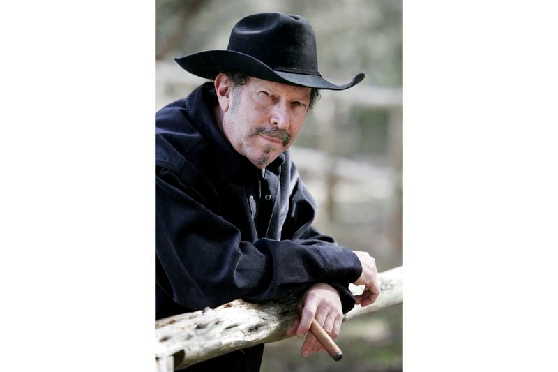 FILE - Musician and author Kinky Friedman smokes a cigar at his ranch near Medina, Texas, Friday, Jan. 21, 2005. Friedman, the singer, songwriter, satirist and novelist who also dabbled in Texas politics with a campaign for governor, died Thursday at his family’s Texas ranch near San Antonio. He was 79. (AP Photo/Eric Gay, File)