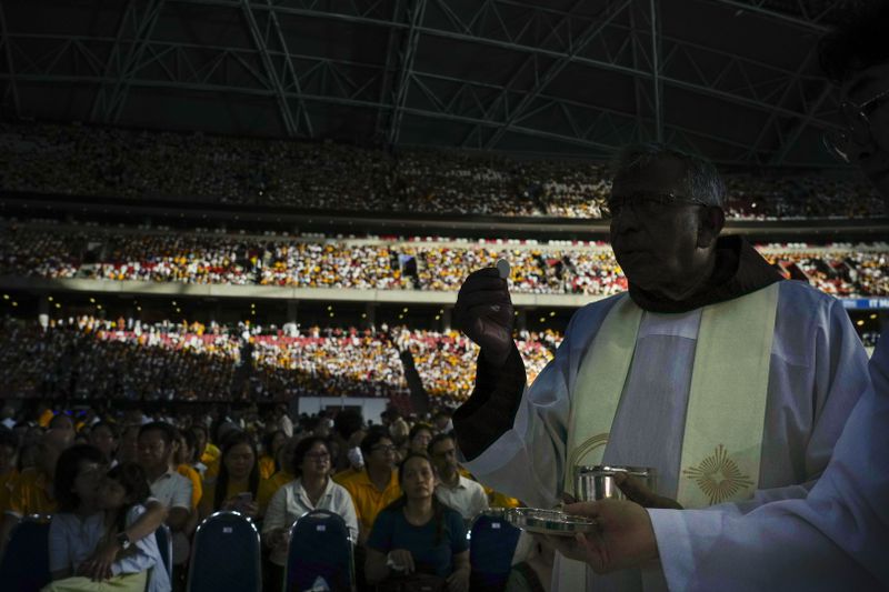 The holy communion is given to the faithful during a mass 'In Memory of the Most Holy Name of Mary' presided over by Pope Francis and celebrated by the Archbishop of Singapore, Cardinal William Goh Seng Chye at the Singapore SportsHub National Stadium, Thursday, Sept. 12, 2024. In Singapore, his final stop of an 11-day trip to Asia and Oceania, Francis once again ditched his remarks when he arrived at the last event, a meeting of Singaporean youth on Friday morning."That's the talk I prepared," he said, pointing to his speech and then proceeding to launch into a spontaneous back-and-forth with the young people about the need to have courage and take risks. (AP Photo/Gregorio Borgia)