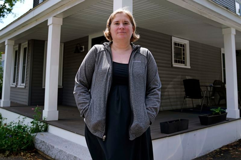 Rebecca Wood stands for a portrait outside her home, Friday, Aug. 30, 2024, in Maynard, Mass. Wood noticed a "program fee" required each time she loaded money onto her daughter's school lunch account. (AP Photo/Charles Krupa)