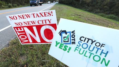 Traffic on Enon Road passes by signs for and against forming the City of South Fulton. Curtis Compton /ccompton@ajc.com AJC File Photo