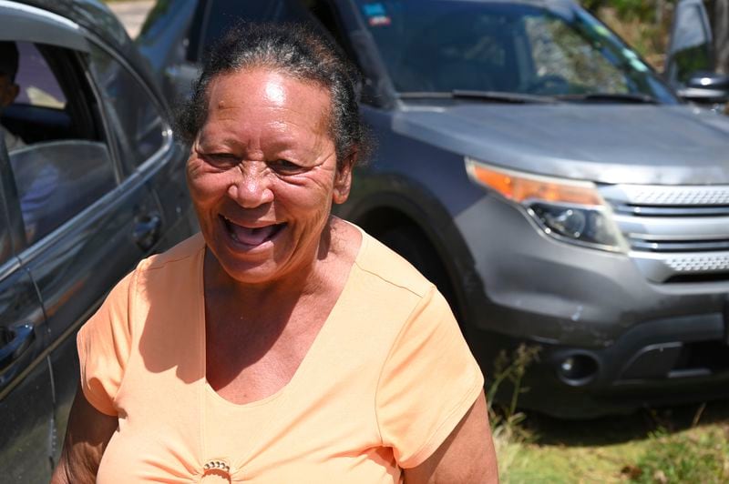 Alance Wisdom smiles broadly during a gathering at her home on Thursday, Aug. 22, 2024, in Cross Keys, Jamaica. (AP Photo/Collin Reid)