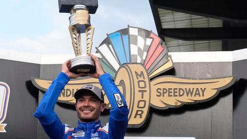 Kyle Larson holds the trophy after winning a NASCAR Cup Series auto race at Indianapolis Motor Speedway, Sunday, July 21, 2024, in Indianapolis. (AP Photo/Darron Cummings)