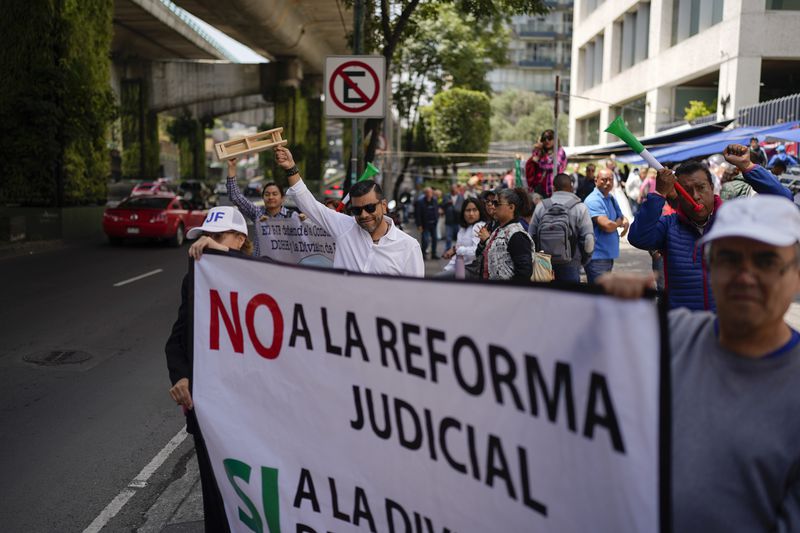 Unionized federal court workers strike over reforms that would make all judges stand for election, outside a federal court in Mexico City, Tuesday, Aug. 20, 2024. (AP Photo/Eduardo Verdugo)