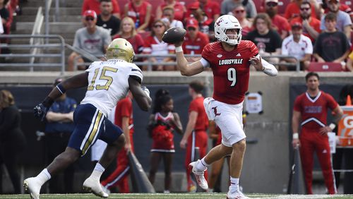 Louisville quarterback Tyler Shough (9) attempts a pass while being pursued by Georgia Tech linebacker Tah'j Butler (15) during the first half of an NCAA college football game in Louisville, Ky., Saturday, Sept. 21, 2024. (AP Photo/Timothy D. Easley)