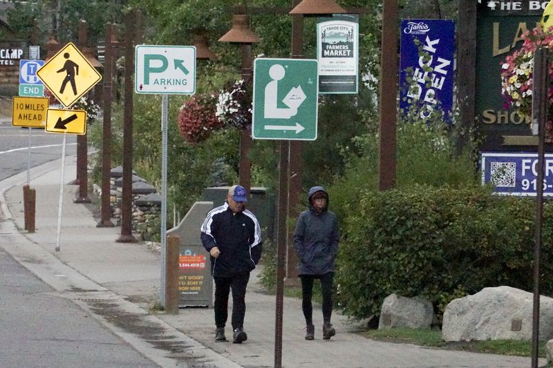 Pedestrians walk in the rain Saturday, Aug. 24, 2024, in Tahoe City, Calif. (AP Photo/Brooke Hess-Homeier)