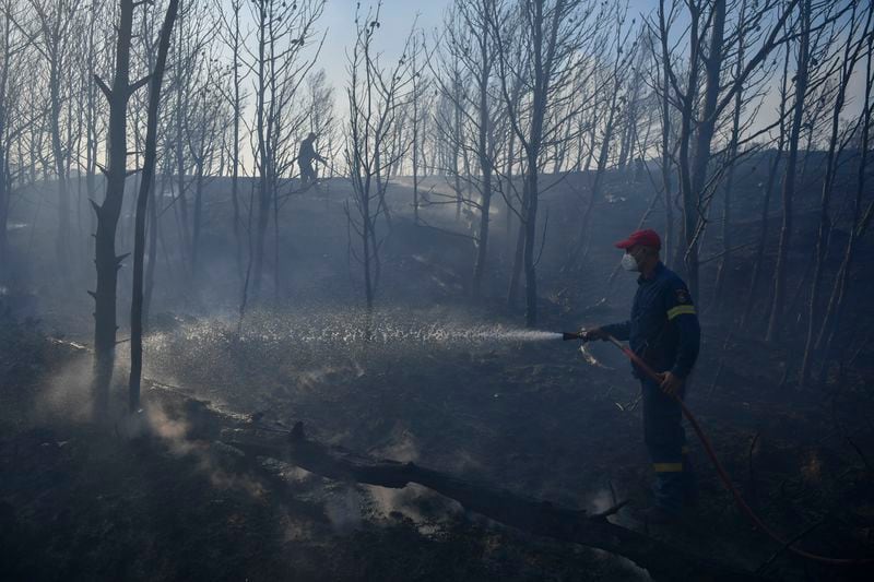 Firefighters operate near Penteli, northeast of Athens, Greece, Monday, Aug. 12, 2024. Hundreds of firefighters backed by dozens of water-dropping planes and helicopters were battling the flames from first light Monday.(AP Photo/Michael Varaklas)