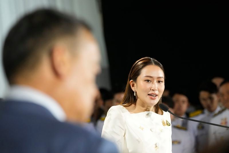 Thailand's new Prime Minister Paetongtarn Shinawatra, right, and former Thai Prime Minister Srettha Thavisin, left, talk to media members after receiving the royal endorsement for the post, Sunday, Aug. 18, 2024, at the Pheu Thai party headquarters in Bangkok, Thailand. (AP Photo/Sakchai Lalit)