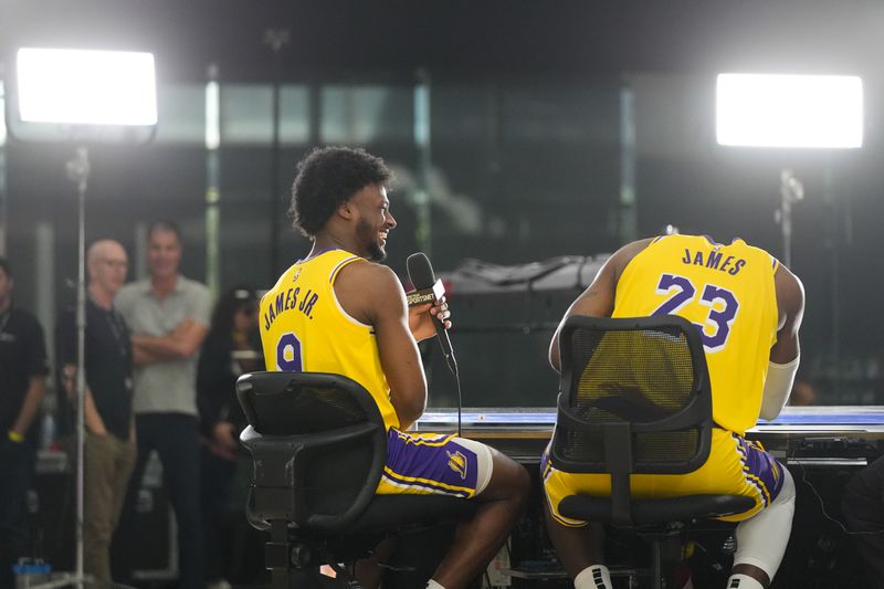 Los Angeles Lakers' LeBron James, right, reacts as he listens to his son, Bronny James Jr., during an interview at the NBA basketball team's media day in El Segundo, Calif., Monday, Sept. 30, 2024. (AP Photo/Jae C. Hong)