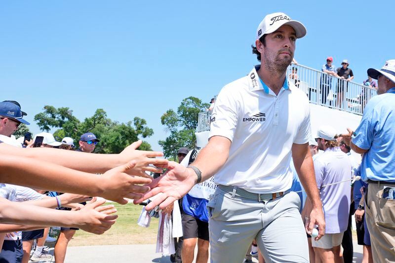 Fans in the gallery reach out to Davis Riley as he walks to the the tenth tee box during the final round of the Charles Schwab Challenge golf tournament at Colonial Country Club in Fort Worth, Texas, Sunday, May 26, 2024. (AP Photo/LM Otero