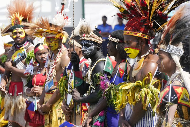 People in traditional dress stand in front of the stage as Pope Francis gives an address during meeting with young people in the Sir John Guise Stadium in Port Moresby, Papua New Guinea, Monday, Sept. 9, 2024. (AP Photo/Mark Baker)