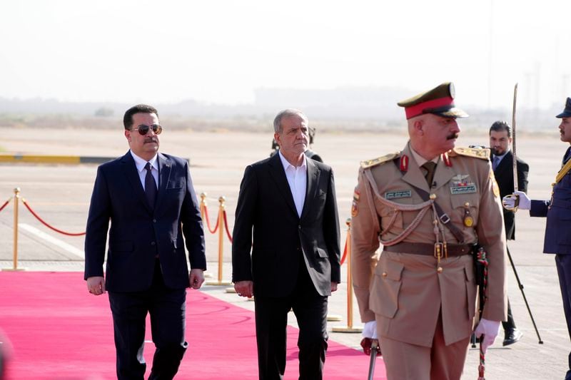 Iranian President Masoud Pezeshkian is welcomed by Iraqi Prime Minister Mohammed Shia al-Sudani, left, with an official ceremony at the Baghdad International Airport in Baghdad, Iraq, Wednesday Sept. 11, 2024. (Murtadha Al-Sudani/Pool Photo via AP)